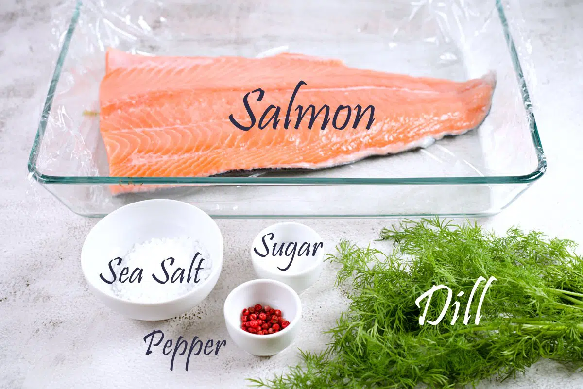 Salmon fileet, fresh dill, sea salt, sugar and pepper in bowls. 