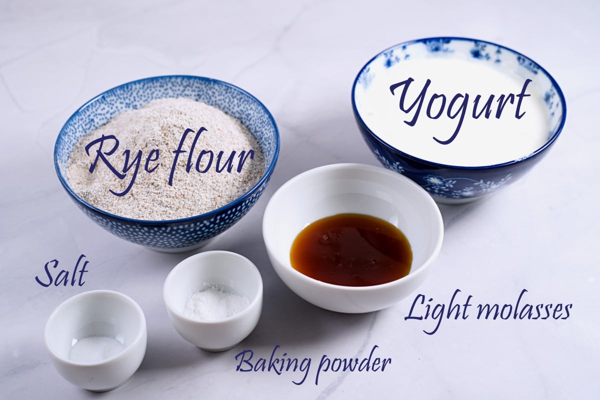 yogurt, rye flour, syrup, baking powder and salt in small blue cups. 