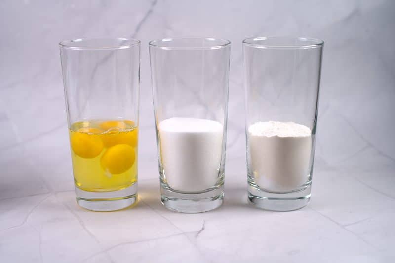 3 glasses with eggs, sugar and flour. 
