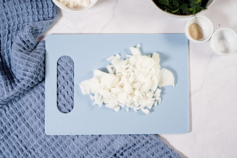 chopped onion on blue plastic board. 