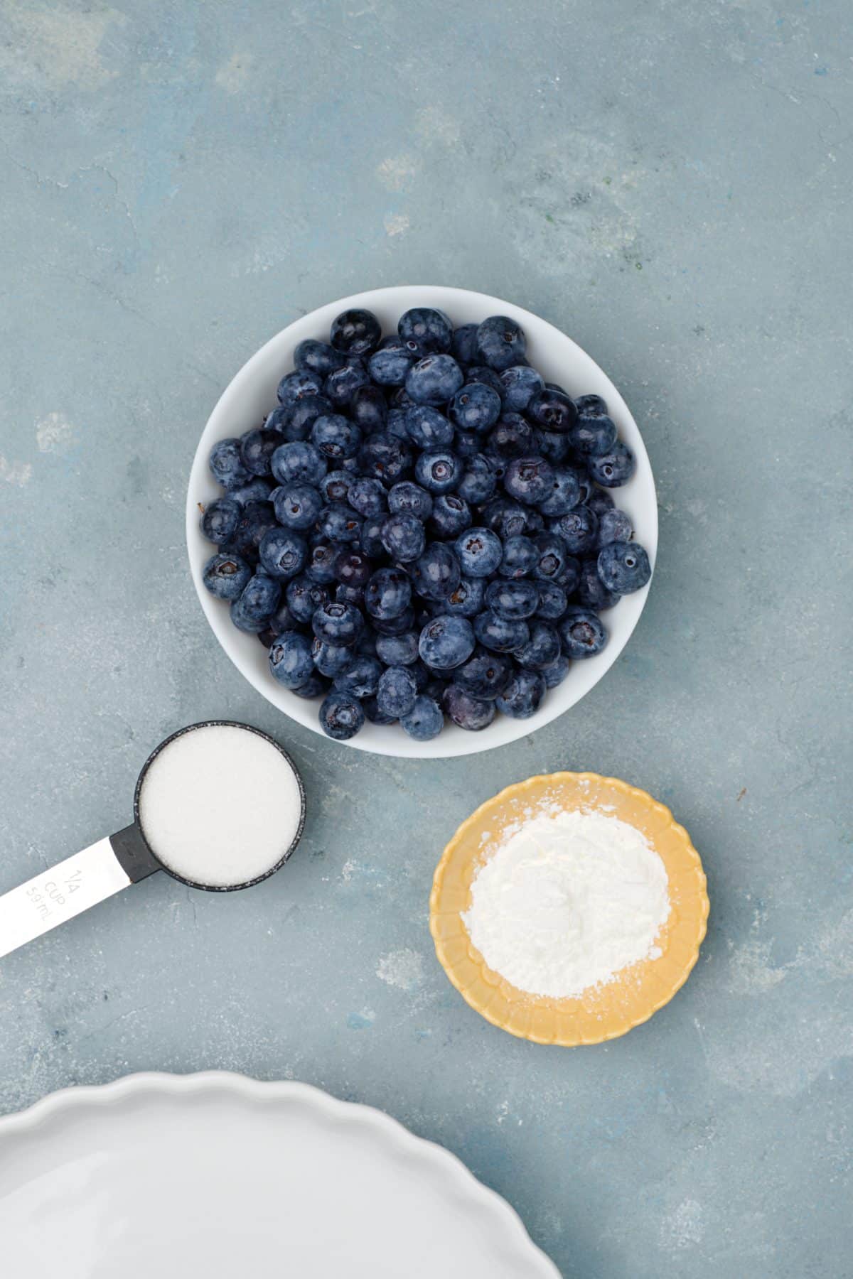 Blueberries, sugar and starch in small bowls. 