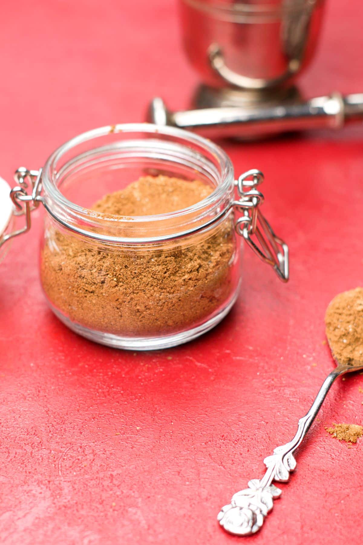a brown spice blend in jar and on spoon. 