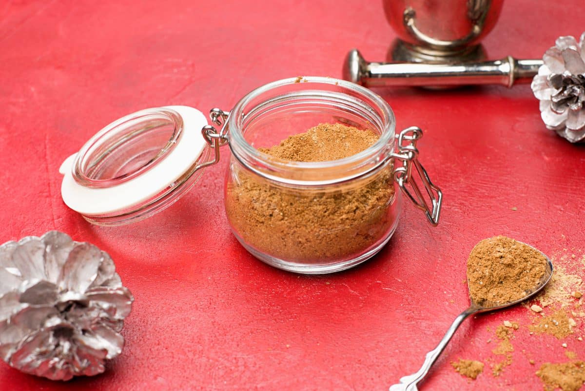 mortar and pestle on background with ready gingerbread spicemix on front of picture. 
