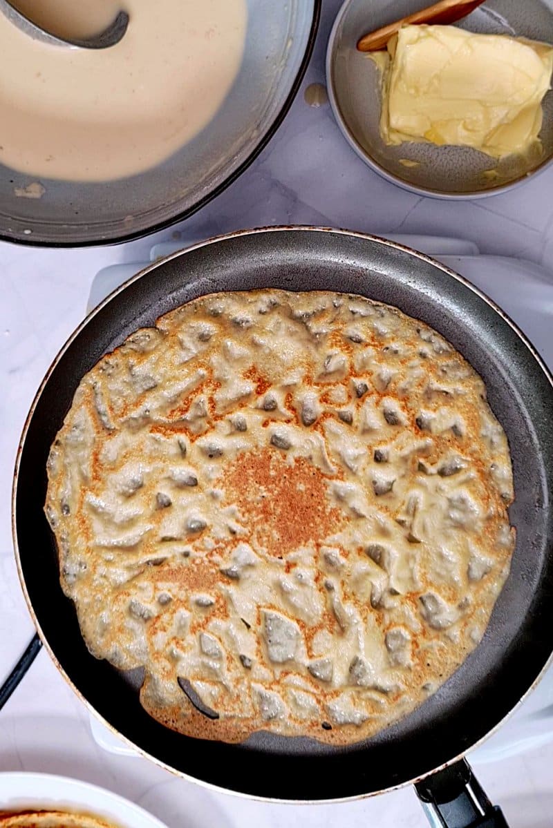 A lace patterned pancake on pan. 