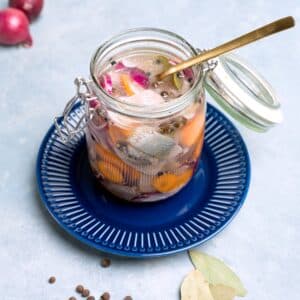 pickled herring in glass jar with fork.