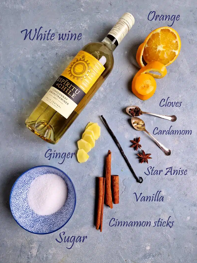 ingredients for white mulled wine on blue surface with name labels. 