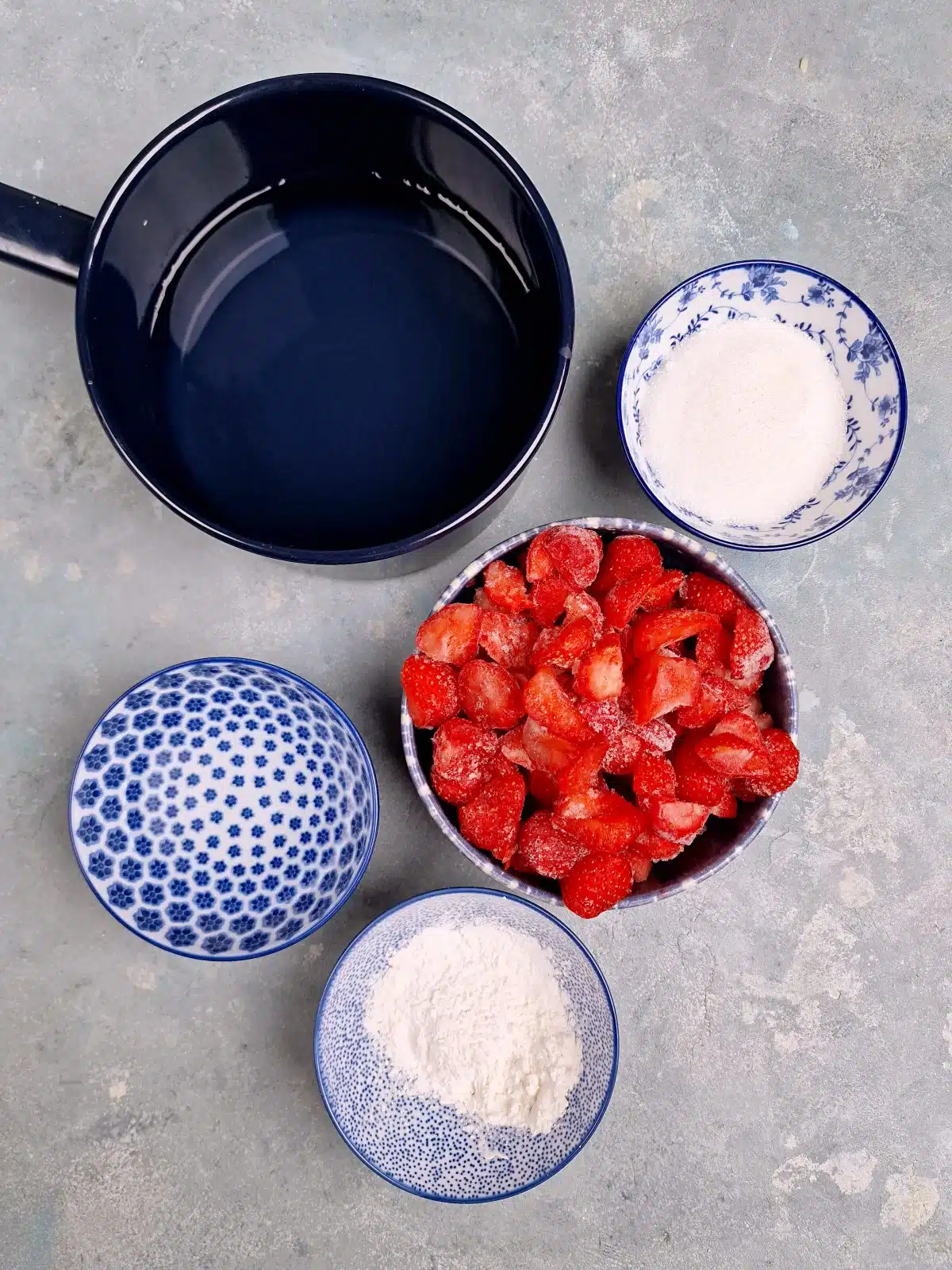 strawberries, sugar, potato starch and water in bowls. 