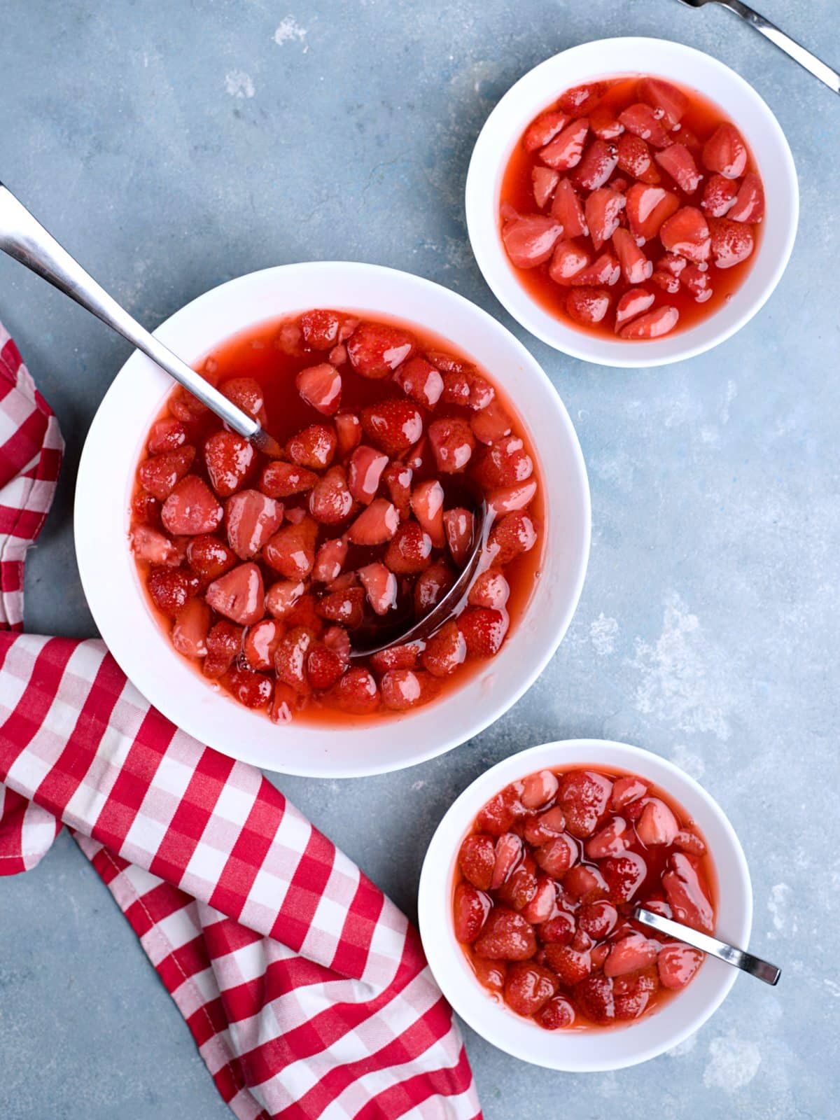 Strawberry soup in large bowl with pieces in it. A red cloth decorating the blue surface. 
