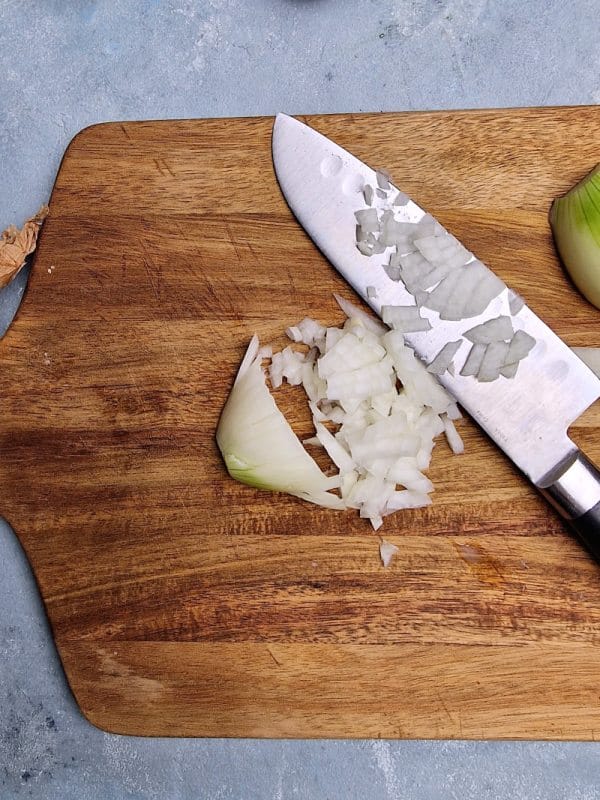 chopped onion on board with knife. 