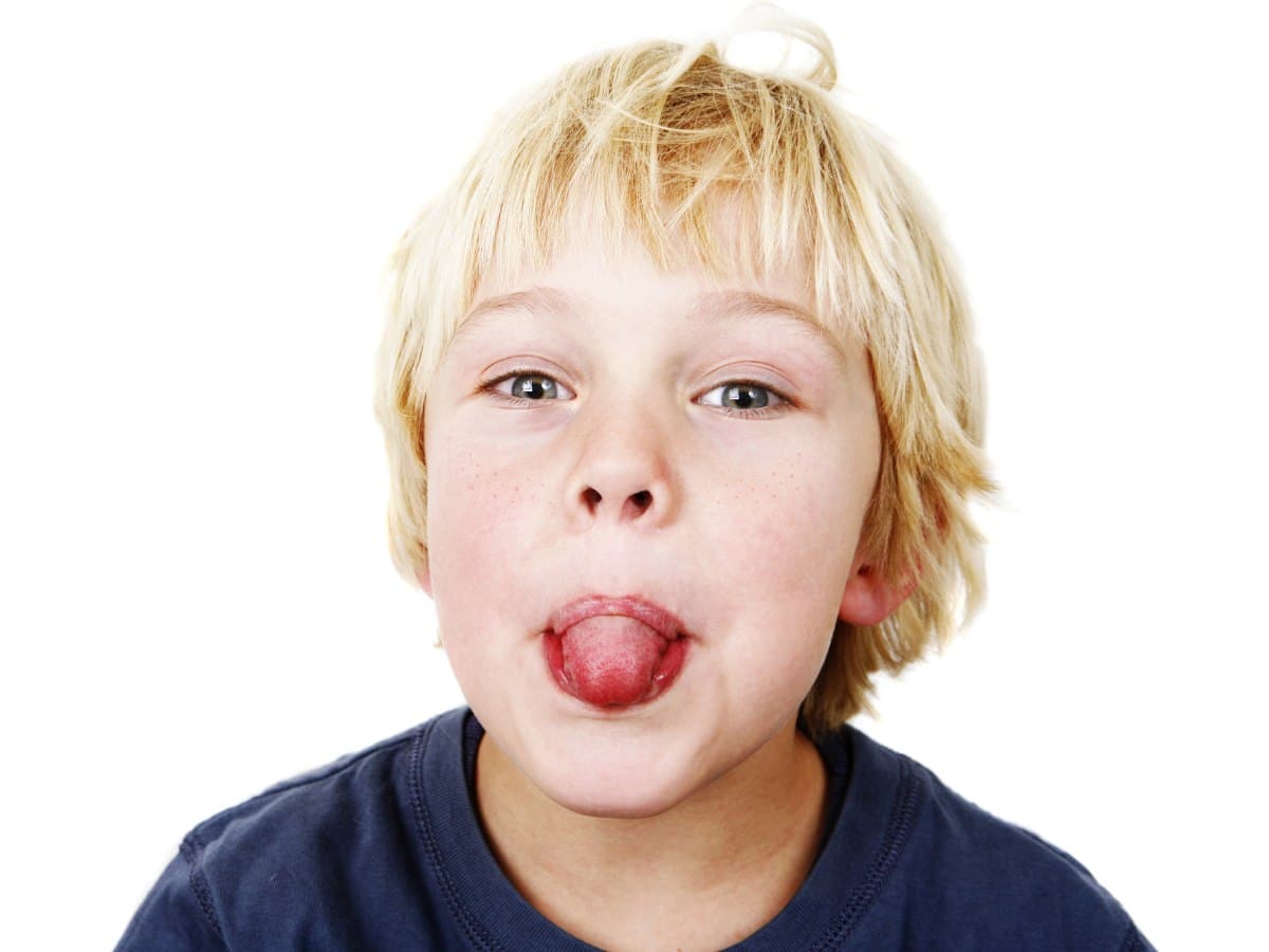 Blonde boy showing his tongue. 