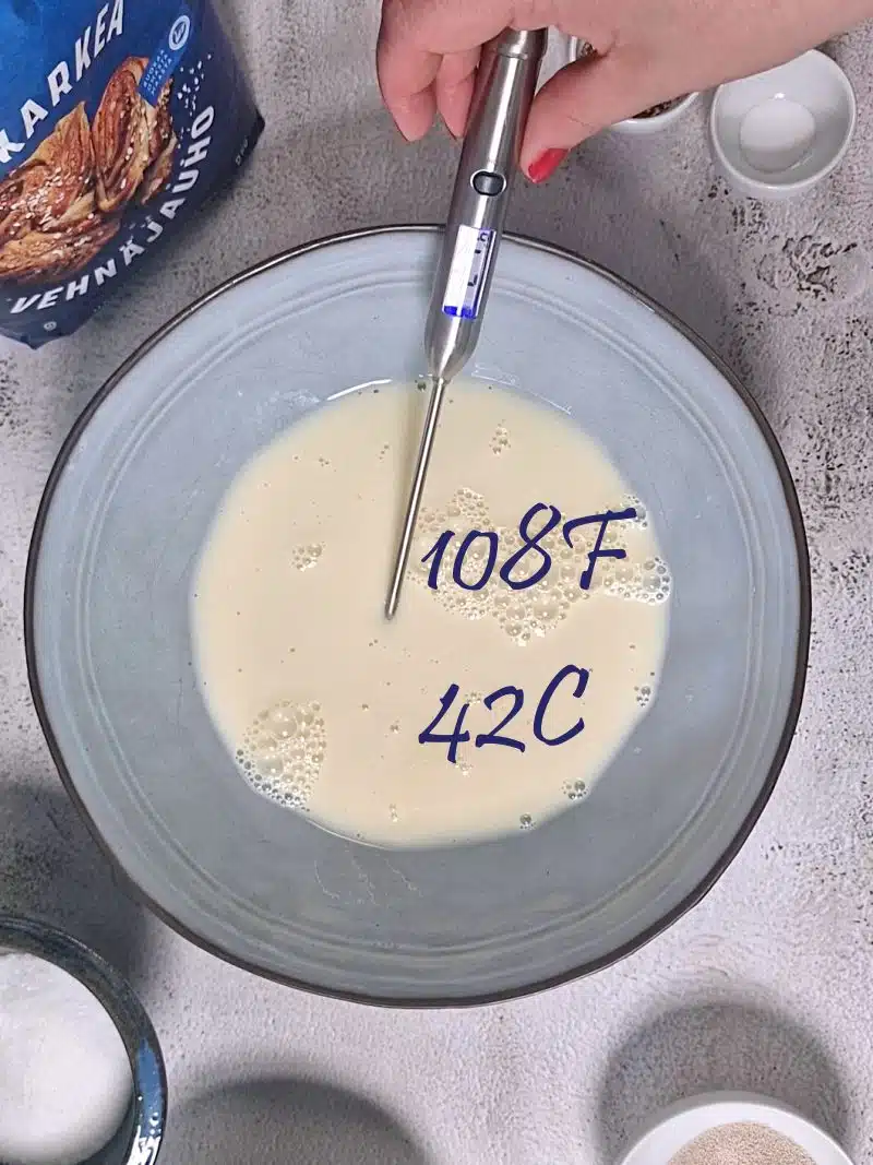 milk in blue bowl with thermometer. 