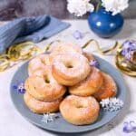 round sugared donuts on blue plate with floower and gold decorations.