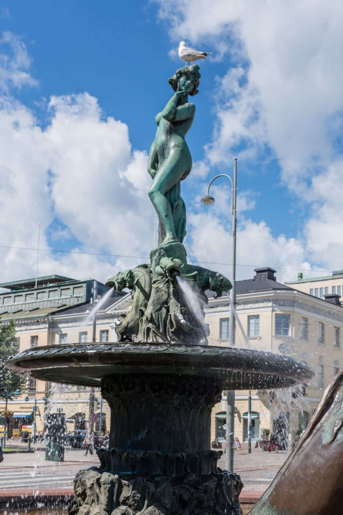 A statue of naked girl with water spitting dragons. 
