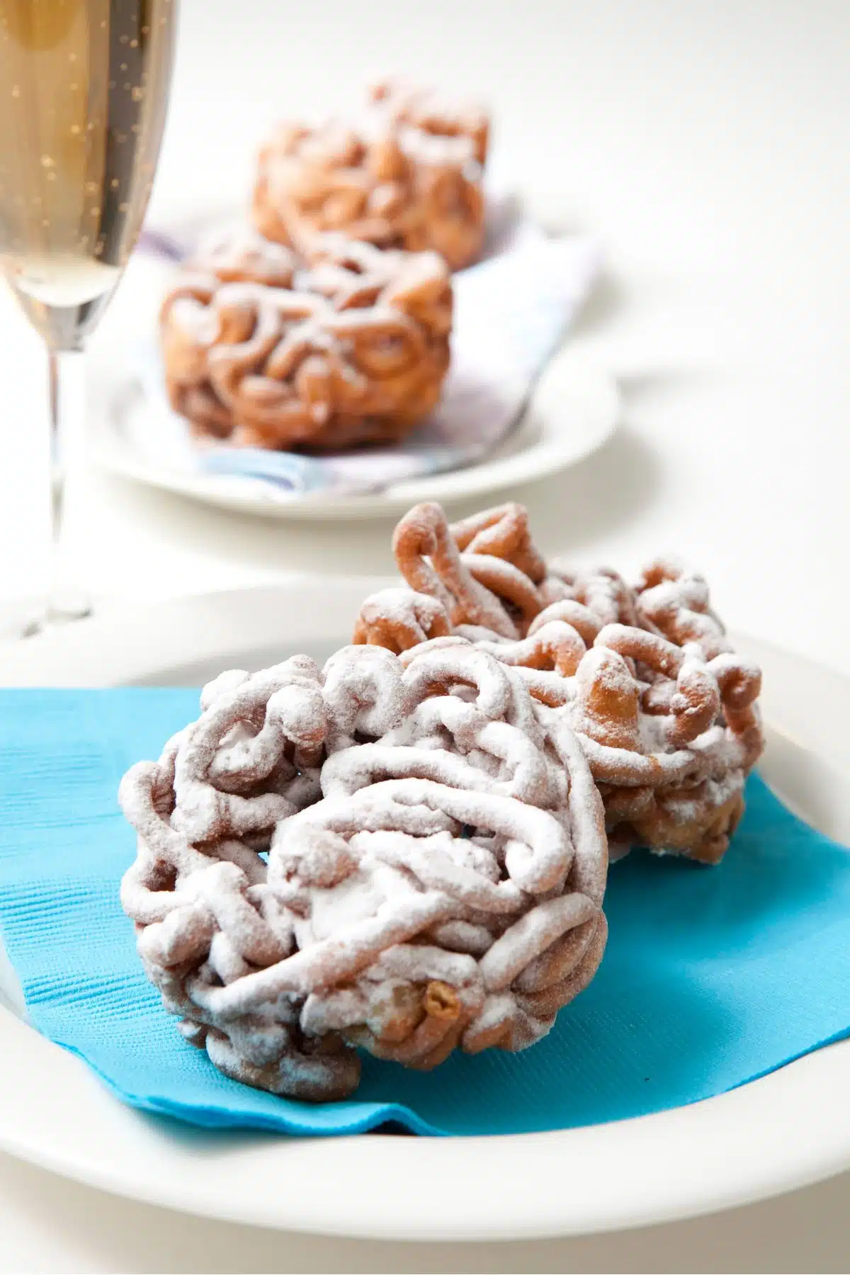 Funnel cakes with sparkling wine and decorated with powdered sugar.  