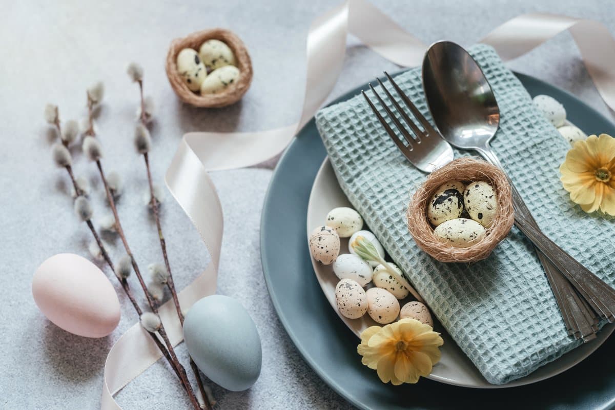 A dressed table with blue tableware and easter eggs. 