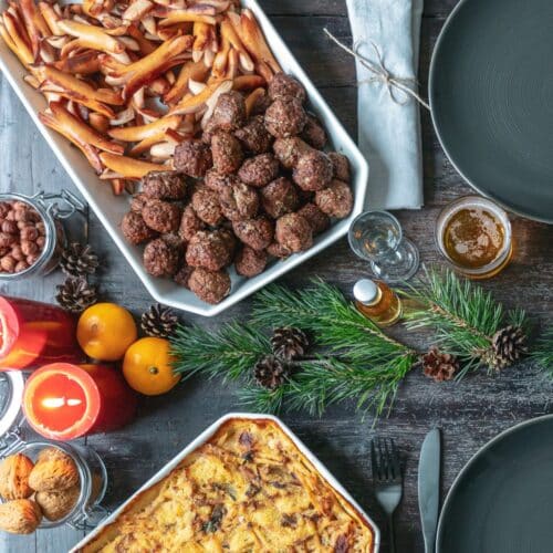 Swedish dinner table with sausages, meatballs and potato casserole.