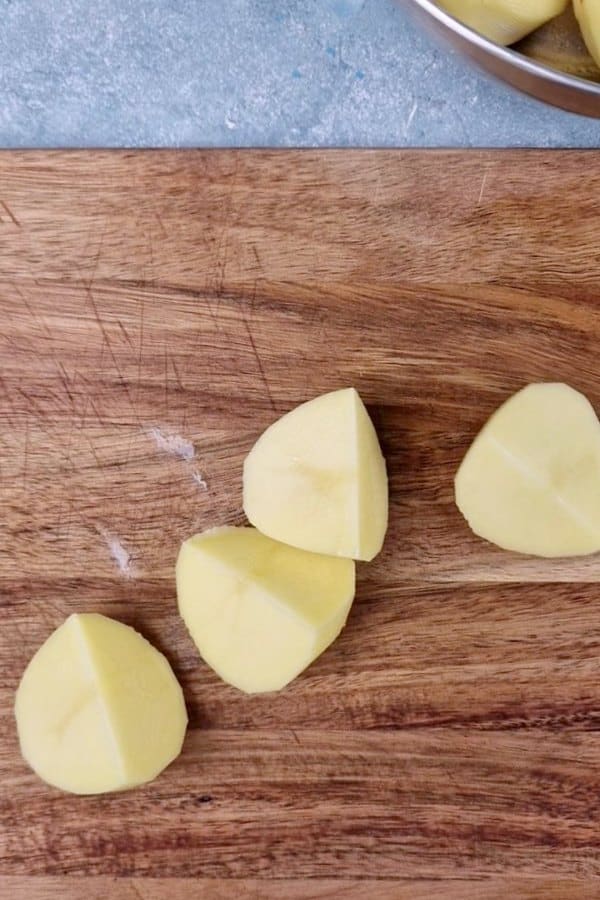 chopped potato chunks on chopping board. 