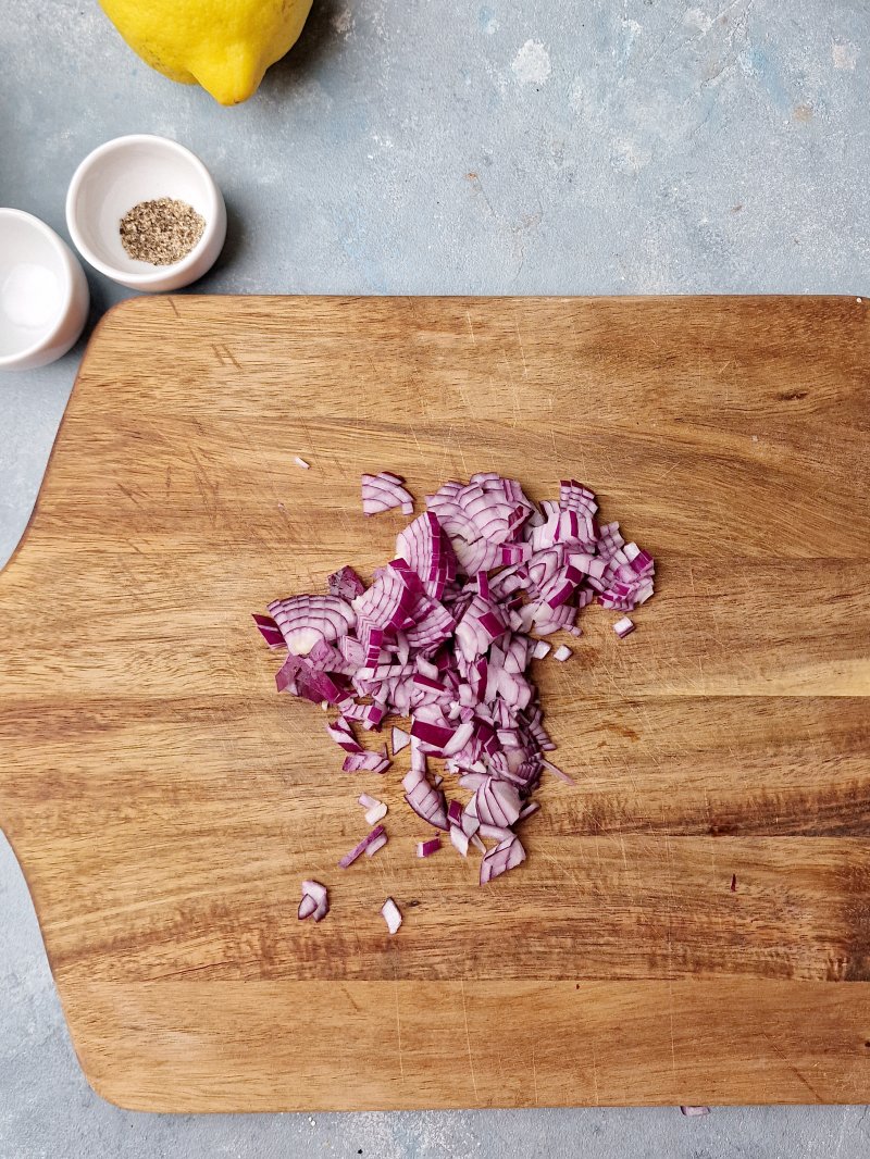 chopped red onion on wooden cutting board. 
