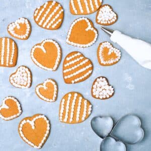 An icing piping bag and decorater heart shaped gingerbreads.