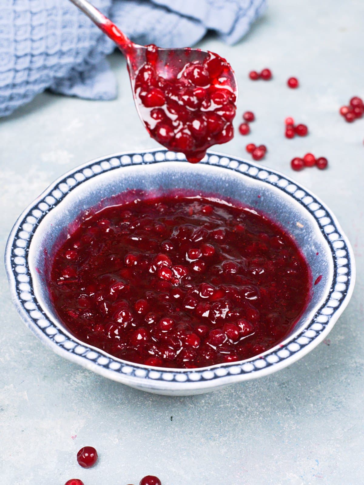 Lingonberry jam in a decorative blue bowl and spoon. 