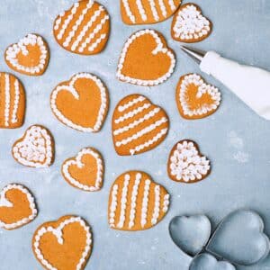 Thin Gingerbread cookies on blue surface with white kristyr on top as decoration.