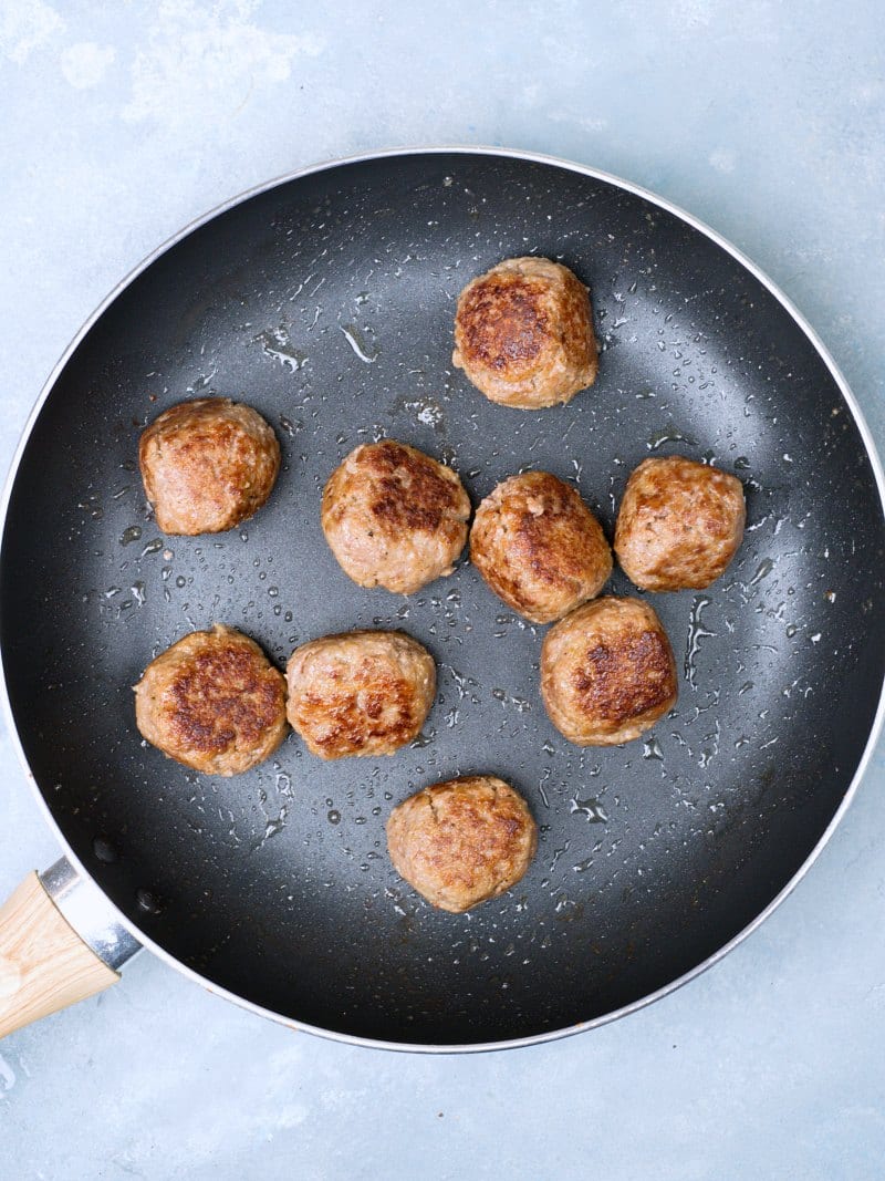 Brown fried meatballs on a non-stick pan. 