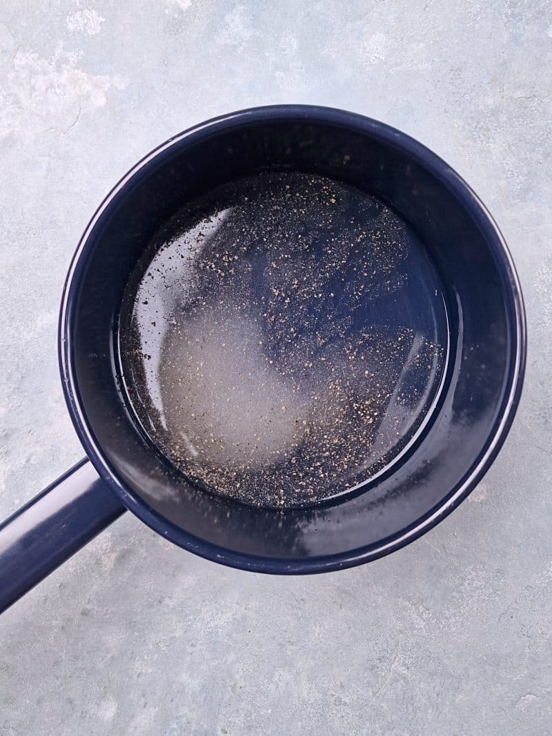 liquid, sugar, salt and pepper in a small blue pot. 