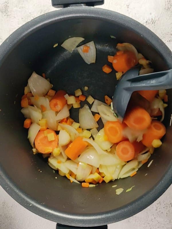 sauteing veggies like carrot and onion in a large pan. 