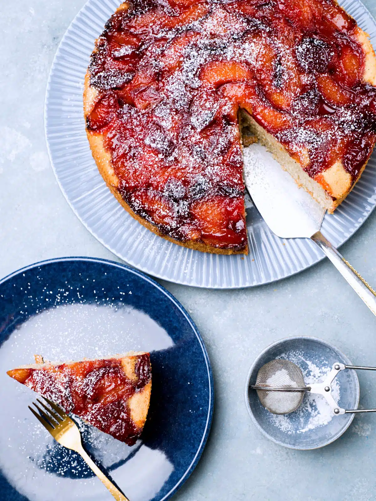 Plum cake and a slice served on a platter. 