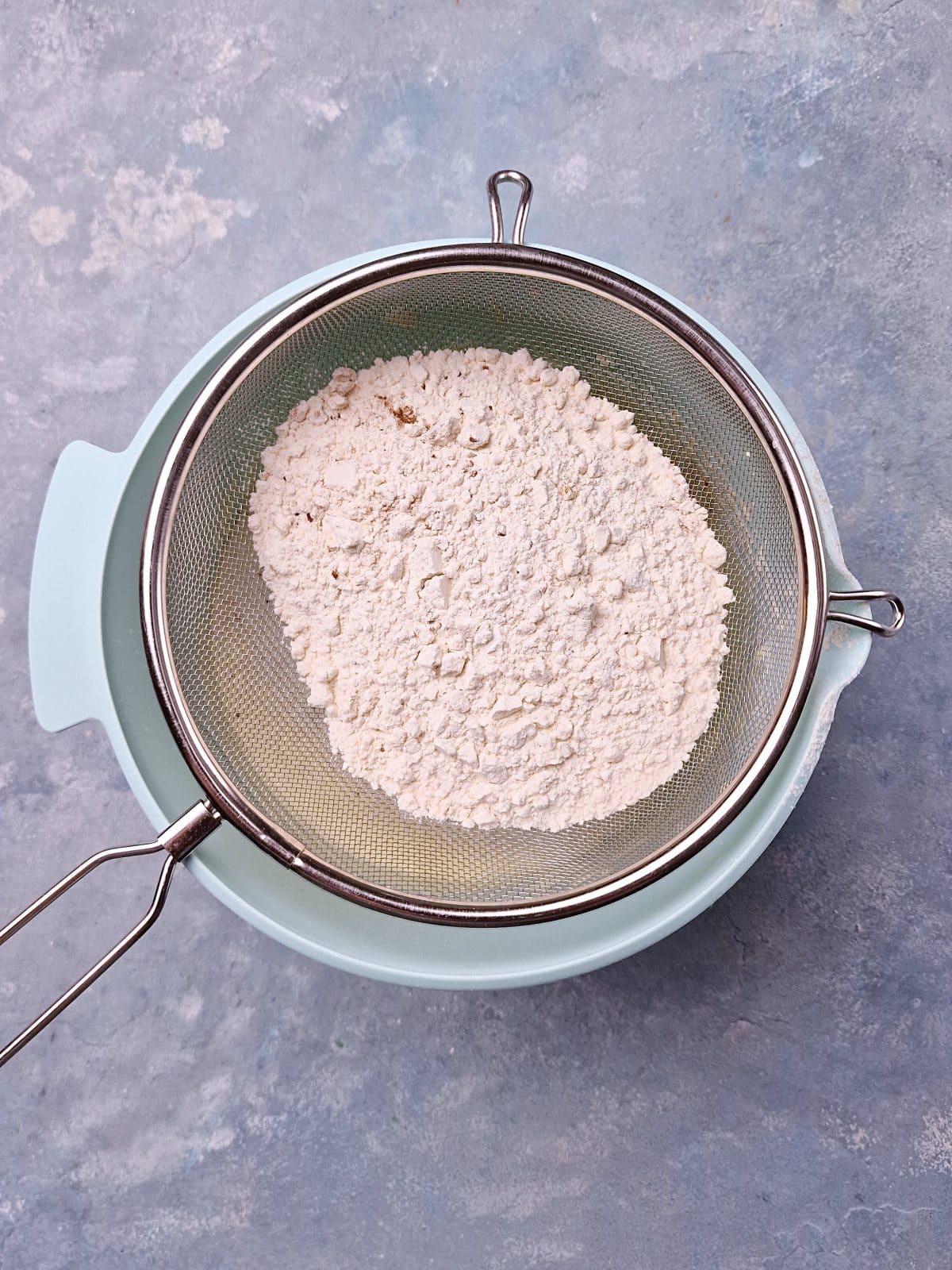 Sieving flour in a fluffy egg mixture. 