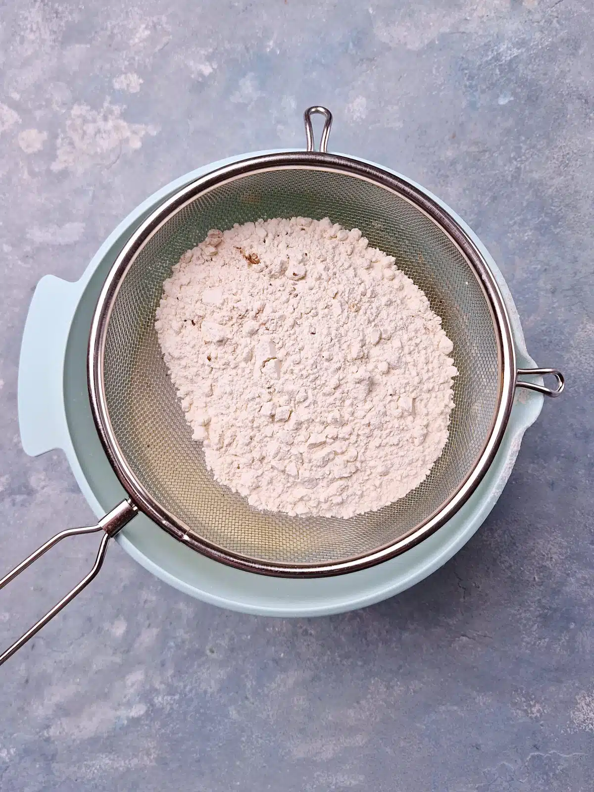 Sieving flour in a fluffy egg mixture. 