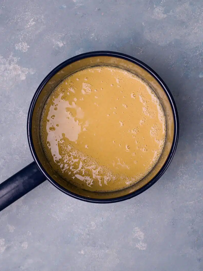 Yellow liquid in dark blue pan.