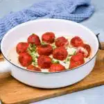 Closeup on meatballs in white pan lying in cream sauce and decorated with parsley