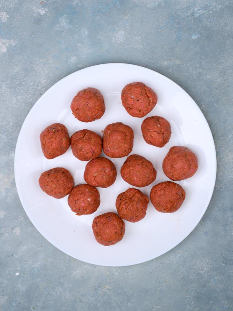 14 rolled meatballs on plate. 