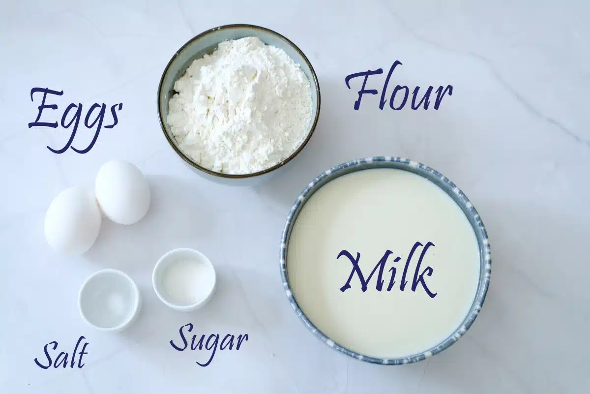 Ingredients for panckakes in bowls, milk, flour, sugar and salt. 