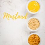 Yellow mustard in a bowl, mustard powder and mustard seeds.